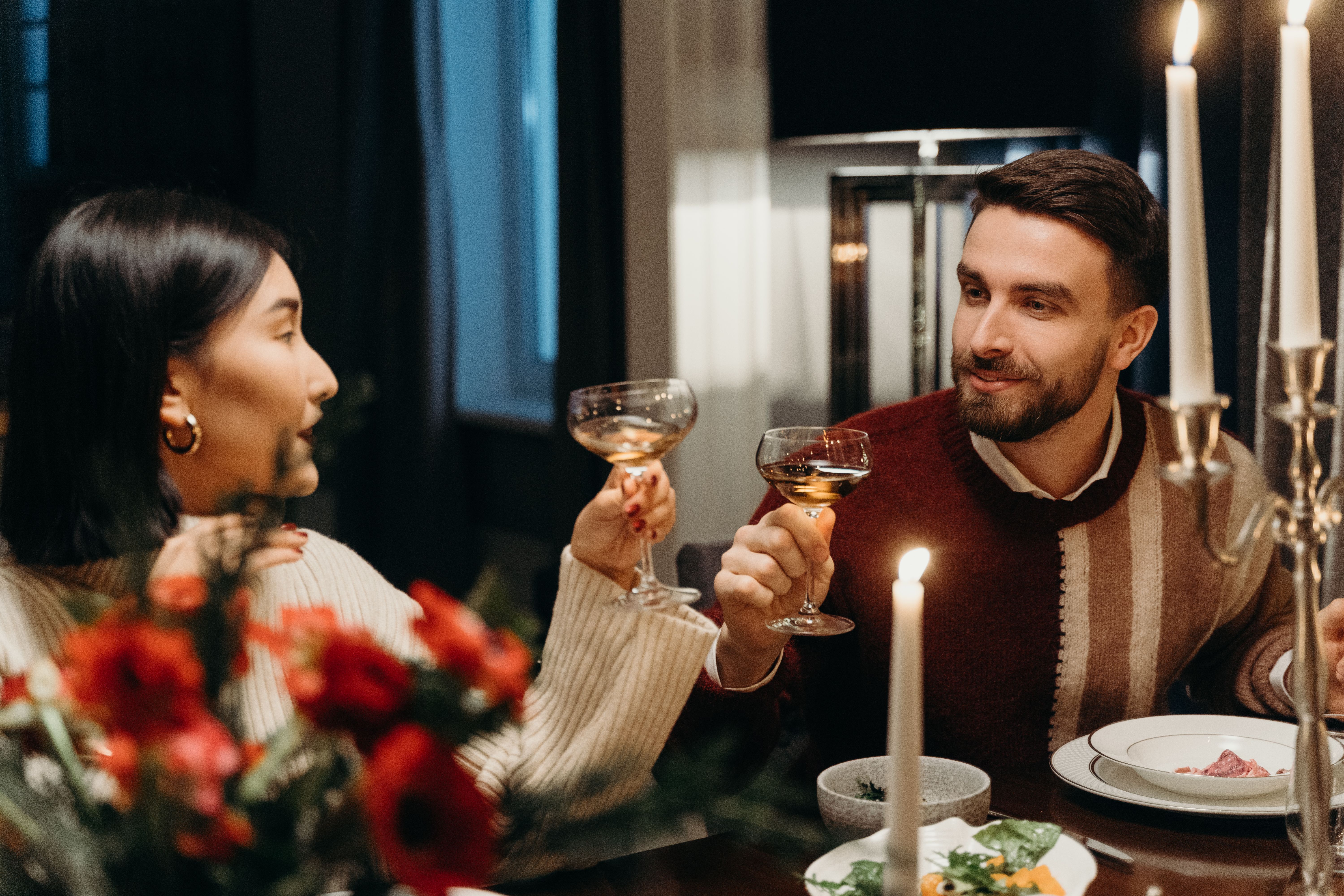Couple enjoying a romantic candlelit dinner, representing the personal connection at the heart of companion services
