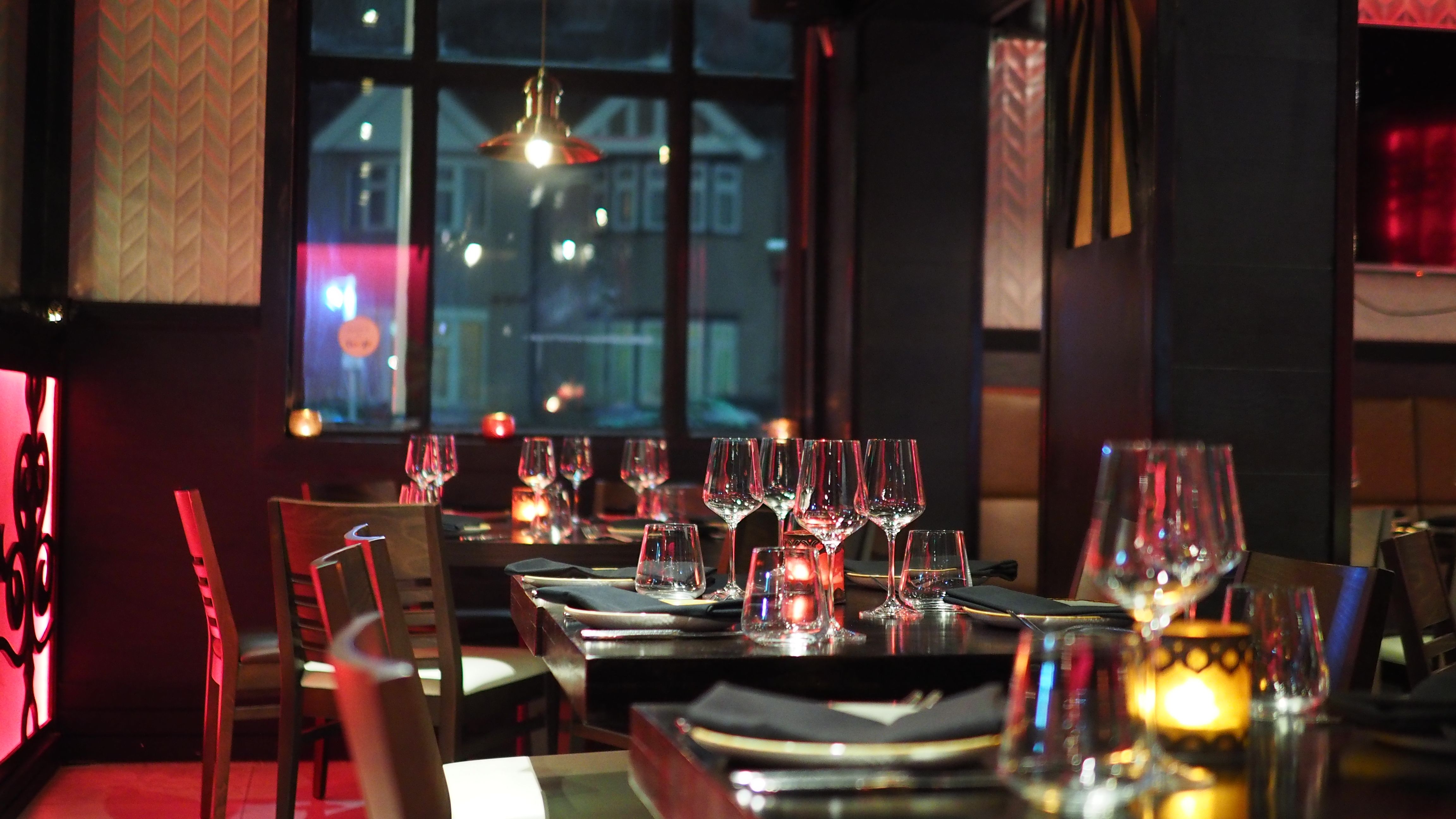 Upscale restaurant interior with candlelit table setting, the kind of venue exclusive companions attend