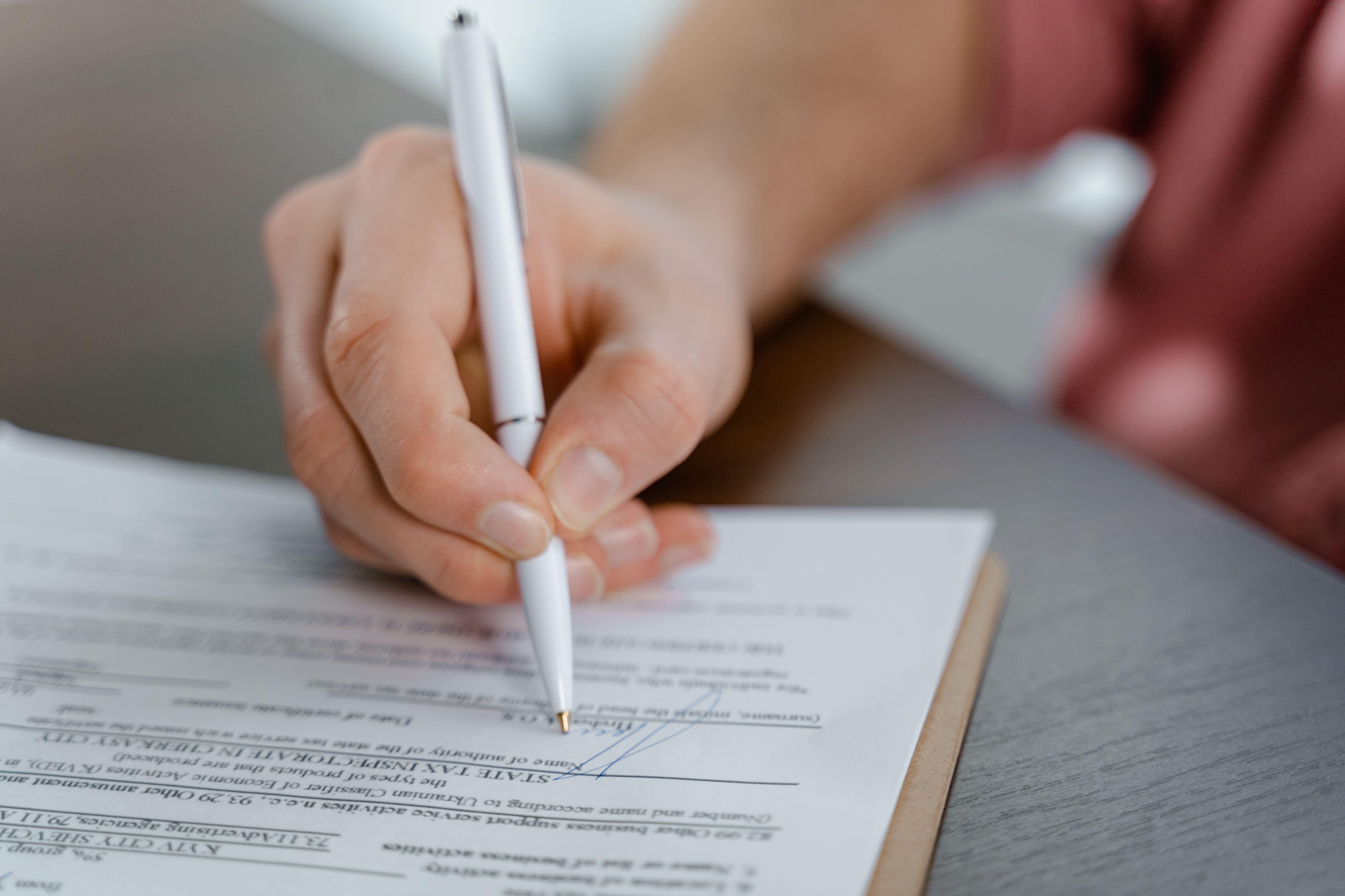 A claimant signing the legal paperwork to join a UK group litigation claim
