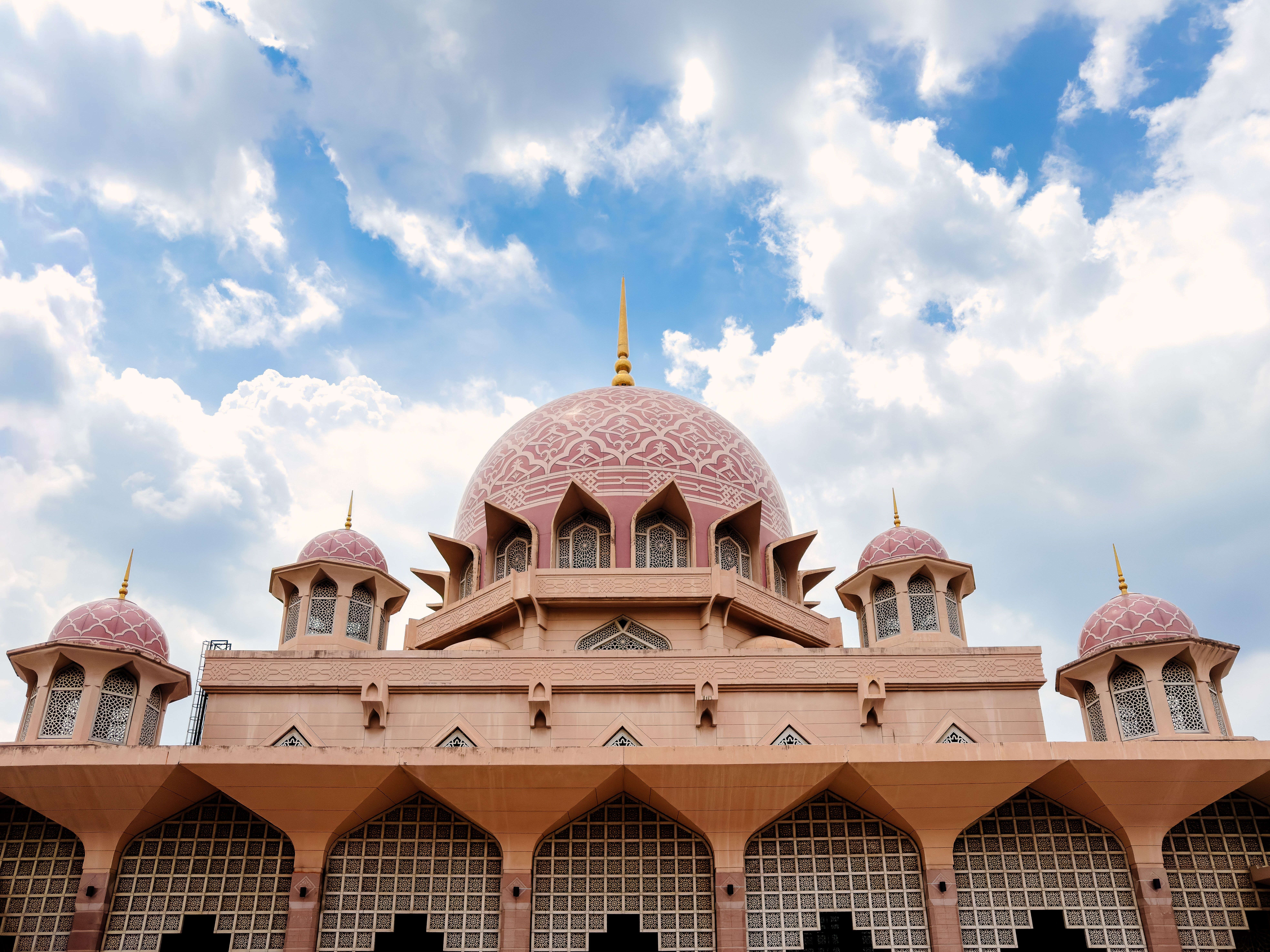Pink-domed Putra Mosque in Putrajaya under a bright blue sky