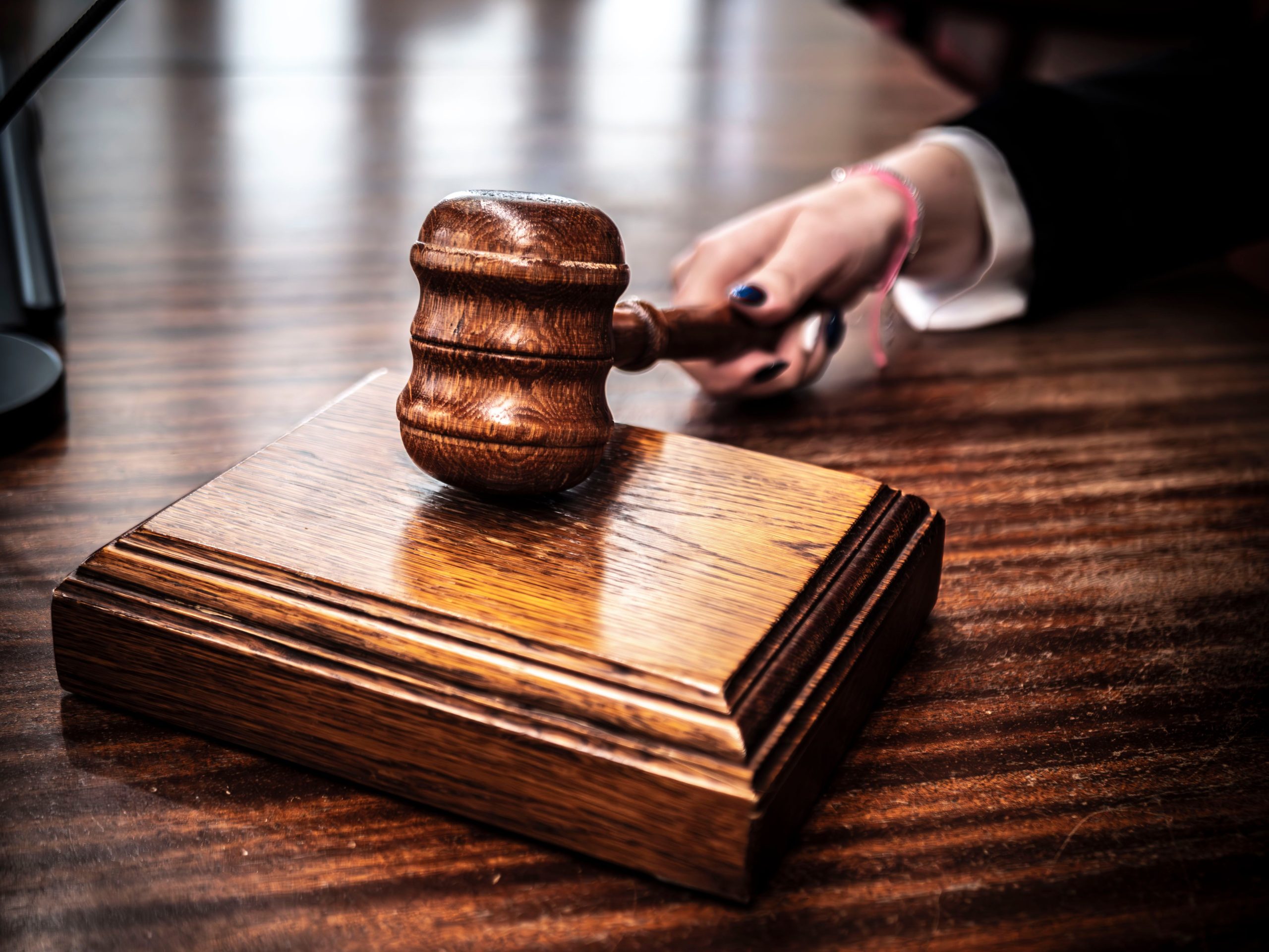 Close-up of a wooden gavel on a judge's desk, symbolizing justice